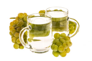 Weiße Mischung (Weinschorle) mit Trauben auf weißem Hintergrun